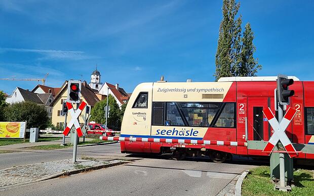 Zug der Biberbahn an einem Bahnübergang in Meßkirch
