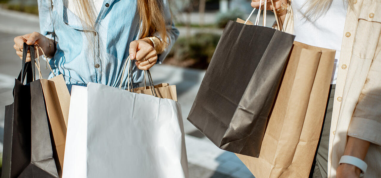 Von zwei Frauen getragene Einkaufstüten bei einer Shoppingtour