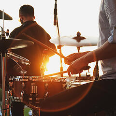 Schlagzeuger einer Band beim Sonnenuntergang