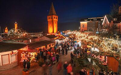 Blick auf die Lindauer Hafenweihnacht an der Promenade unter dem Mangturm
