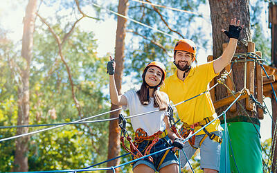 Partner-Parcours Paar klettert gemeinsam in einem Kletterwald
