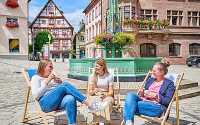 Freundesgruppe genießt ein Eis beim Stadtfest am Brunnen in Meßkirch