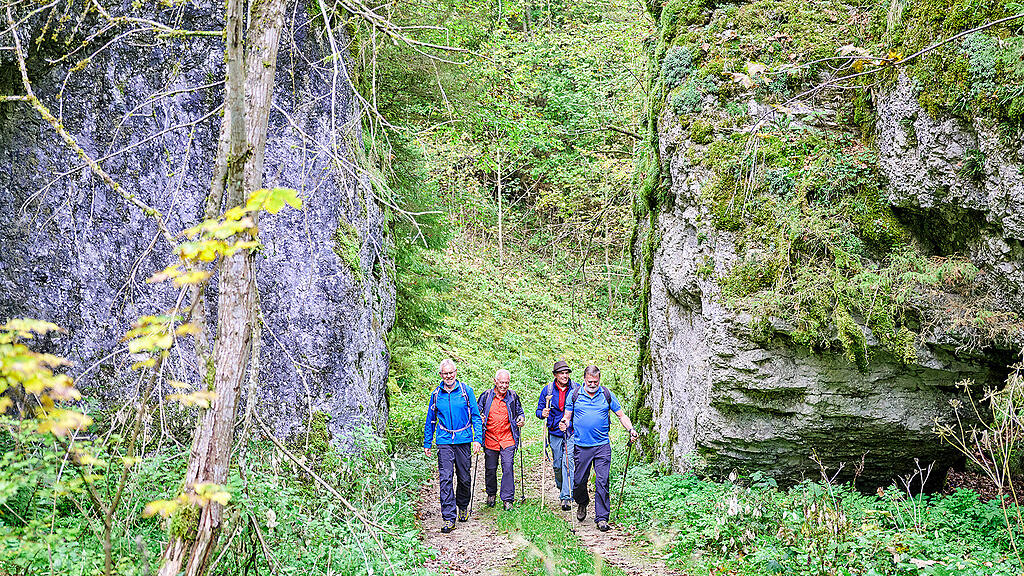 Wandergruppe wandert durch ein Felstor bei Meßkirch
