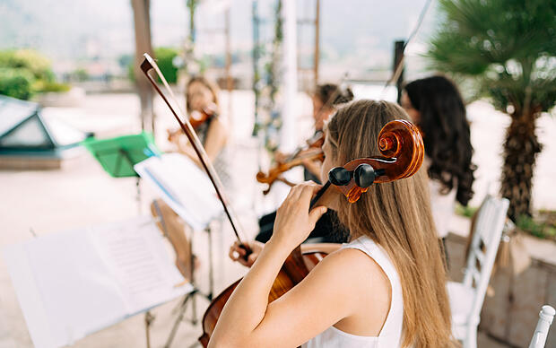 Musizierende Frau mit Cello auf einer Bühne unter freiem Himmel