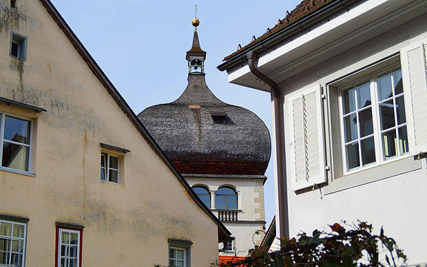 Blick zwischen zwei Gebäuden hindurch auf die Spitze des Martinsturms in Bregenz