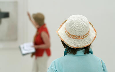Führungen Zuhörerin einer Führung durch eine Kunstgalerie