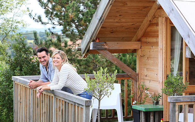 Vermieter-Paar steht auf dem Balkon ihres Ferienhauses Vermieter-Paar steht auf dem Balkon ihres Ferienhauses