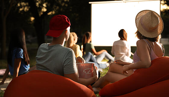 Menschen mit Popcorn vor einen Outdoorkino Menschen mit Popcorn vor einen Outdoorkino
