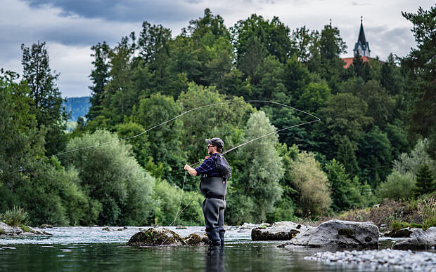 Im Bachstehender Angler mit Fliegenrute