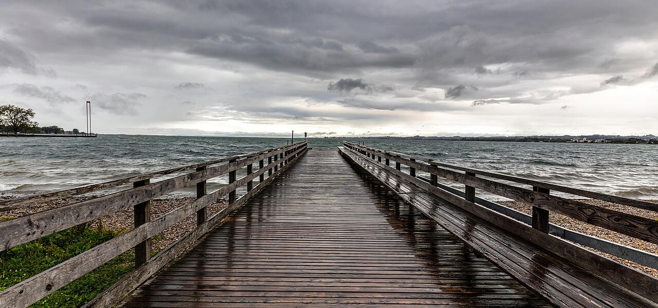 Holzsteg am Bodensee bei Regenwetter und grauem Himmel