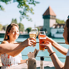 Freundesgruppe im Außenbereich eines Restaurants beim Getränke-Anstoßen in Konstanz
